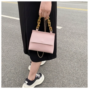 Sac à main rose grainé avec poignée chaîne dorée épaisse et bandoulière fine en or