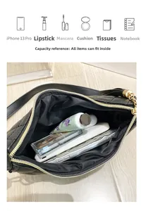 Capacity detail of black quilted crescent bag fitting iPhone, lipstick, and essentials