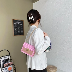 Stylish pink houndstooth crossbody mini chain bag shown being worn by a model