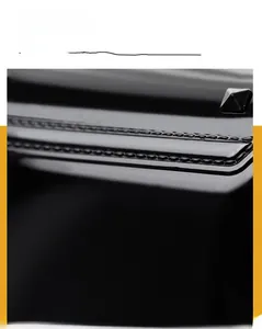 Macro detail of glossy black jelly bag featuring silver pyramid stud and precision stitching
