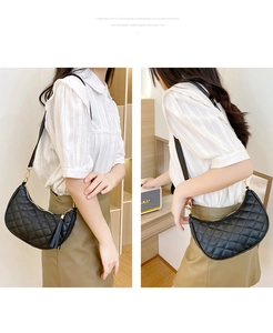Quilted crescent shoulder bag with golden hardware and leather tassel detail on model