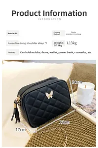 Detail view of black quilted PU square bag with white butterfly charm and gold chain