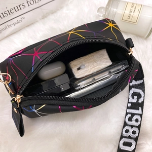 Fashionable black nylon crossbody bag with colorful star pattern and wide logo strap