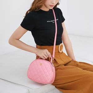 Pink quilted crossbody bag for women with golden clover logo and leather strap