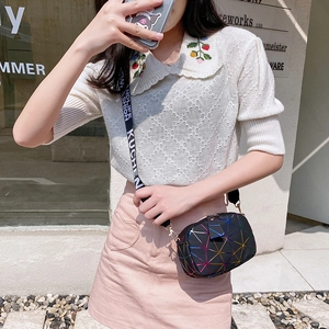 Iridescent geometric crossbody bag with a wide lettered strap on a model outdoors