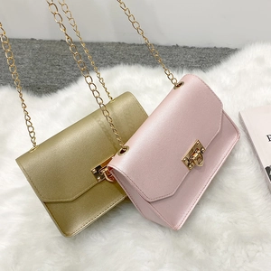 Mini borse a catena minimaliste in ecopelle oro e rosa su sfondo di peluche bianco