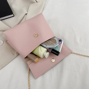 Sac à main rose grainé avec chaîne montrant l'intérieur spacieux et les accessoires