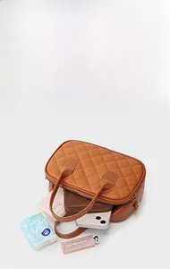 Détails de l'intérieur du sac à main matelassé marron montrant sa grande capacité