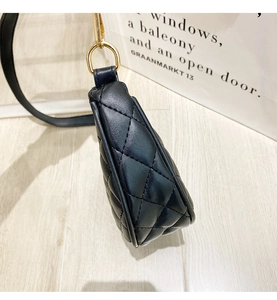 Detail of black quilted leather shoulder bag featuring a side view with gold metal rings
