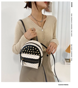 Mini backpack with rivet detailing and pattern print shown on a female model