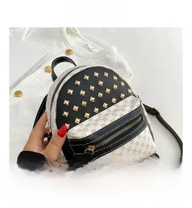 Detail of cream mini backpack with vintage monogram pattern and gold rivets decoration