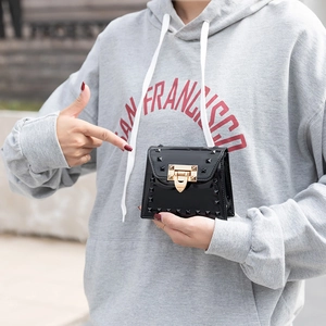 Fashionable black jelly crossbody bag with gold rivets and metallic push-lock closure