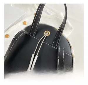 Detail shot of the headphone jack and white contrast stitching on black leather backpack