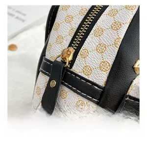 Detail of smooth gold metal zipper and branded monogram leather on contrast backpack