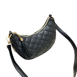 Black quilted crescent shoulder bag with gold hardware and leather tassel detail