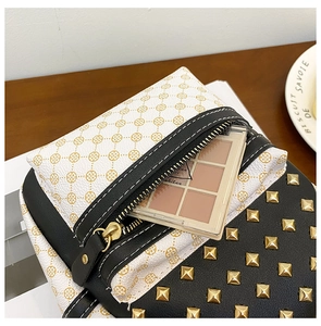 Close-up of contrast color backpack with clover pattern, gold rivets, and a makeup palette