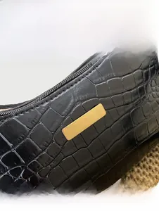 Close-up of black crocodile embossed PU leather shoulder bag with gold metal plate detail