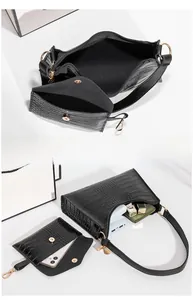 Detail of black crocodile texture shoulder bag interior showing storage for phone and wallet