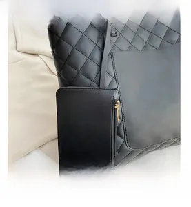 Detail of black quilted tote bag with smooth texture and matching small zipper pouch