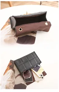 Détail du sac bandoulière matelassé noir avec serrure dorée et intérieur brun spacieux