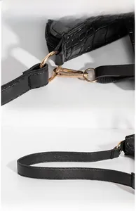 Detail of black crocodile texture leather with high-polished gold vacuum plating hardware