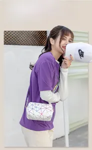 Sac à bandoulière blanc avec patchwork géométrique et lignes colorées sur un mannequin