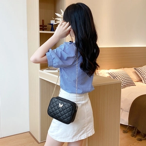 Quilted crossbody bag in black with silver butterfly detail and fine chain strap