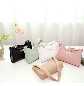 Close-up of woven shoulder bags in various colors with elegant golden metal nameplates