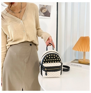 Close-up of contrast rivet mini backpack with gold diamond pattern and leather details
