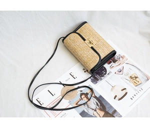 Detalle de bolso bandolera de paja beige con tejido en V y borde de cuero negro