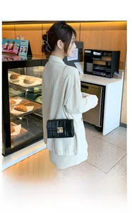 Détail d'un sac bandoulière matelassé noir avec chaîne dorée et fermoir métallique