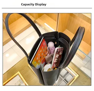 Interior view showing the large capacity of the black tote bag with daily essentials