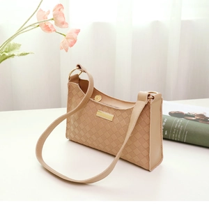 Detail of beige checkered embossed handbag with gold metal plaque and zipper closure