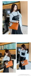 Détail du sac cabas orange matelassé avec bandoulière chaîne et poignée en foulard de soie