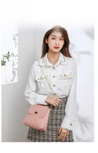 Detailed view of pink quilted handbag with elegant gold heart-shaped lock and chain strap