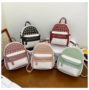 Detail showing five mini backpacks in assorted colors with gold pyramid studs and dot patterns