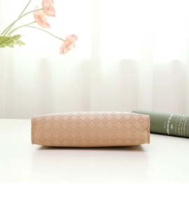 Macro detail of beige woven checkered pattern on stylish leather underarm bag for women