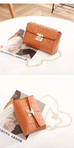 Détail d'un sac bandoulière matelassé caramel avec fermoir doré et bandoulière chaîne