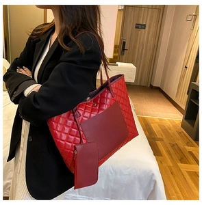 Detail of red quilted tote bag and matching zipper pouch in textured faux leather