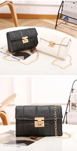 Détail de la texture matelassée et chaîne dorée sur les sacs à bandoulière noir et blanc