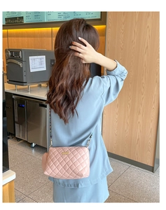 Pink quilted crossbody bag with gold hardware and woven strap shown on a model
