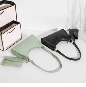 Detail of crocodile pattern shoulder bag and matching coin purse set in green and black