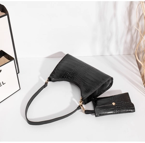 Detail of black crocodile pattern shoulder bag with a small detachable coin purse