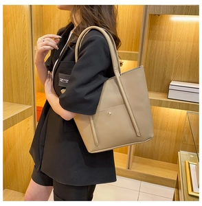 Detail of khaki faux leather large tote bag with gold snap button and double handles