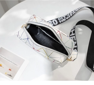 Vue de dessus montrant l'intérieur noir et l'ouverture zippée du mini sac géométrique blanc