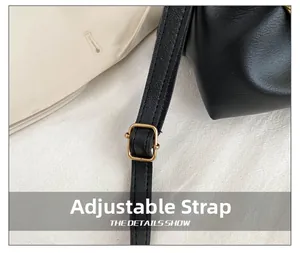 Detail of black leather adjustable shoulder strap with gold metal buckle hardware