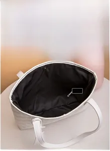 Dettaglio dell'interno della borsa tote trapuntata bianca con grande capacità e chiusura magnetica