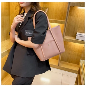 Detail of a pink large capacity tote bag featuring matte PU leather and stitching