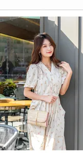 Outdoor shot of a woven crossbody bag paired with a floral V-neck summer dress