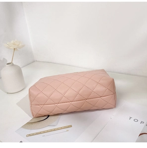 Detailed view of pink quilted leather cosmetic bag with textured diamond pattern finish